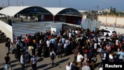 Warga Palestina yang memiliki dwi kewarganegaraan mendatangi penyeberangan perbatasan Rafah dengan Mesir dengan harapan diizinkan meninggalkan Gaza di tengah konflik Israel Palestina, Senin, 16 Oktober 2023. (Foto: Ibraheem Abu Mustafa/Reuters)