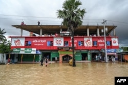 Flood-affected villagers take temporary shelter at an under-construction building in Feni, Bangladesh, Aug. 23, 2024.