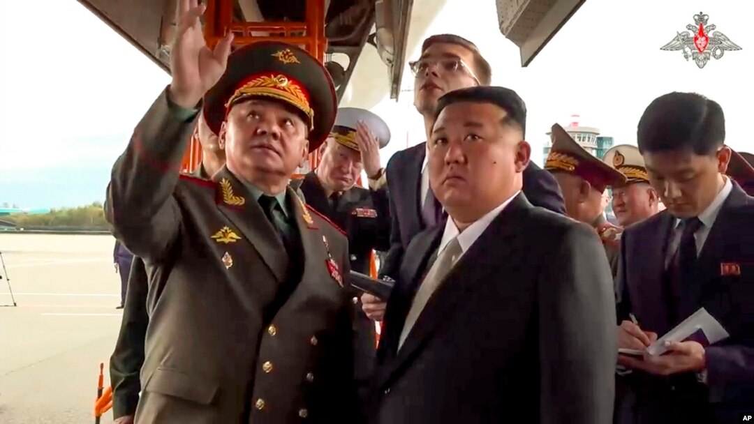 Pemimpin Korea Utara Kim Jong Un mendengarkan Menteri Pertahanan Rusia Sergei Shoigu saat memeriksa pesawat tempur Rusia di Vladivostok, Rusia, 16 September 2023. (Foto: via AP)