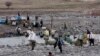 Para portir melintasi anak sungai sambil membawa barang-barang ke Iran di perbatasan Sulaymaniyah, Irak, 15 Februari 2012. (Foto: Reuters/Stringer)