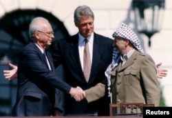 Izraelski premijer Jicak Rabin (levo), američki predsednik Bil Klinton (u sredini) i Jaser Arafat, lider Palestinske oslobodilačke organizacije (PLO) u Vašingtonu, posle potpisivanja mirovnog sporazuma. (Foto: Reuters/Gary Hershorn)