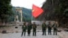 FILE - Members of the Myanmar National Democratic Alliance Army pose with the group's flag in front of the Kunlong bridge in Shan state, Myanmar, Nov. 12, 2023. An offensive against the junta in Myanmar is helping China punish scammers.