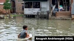 Anak-anak sedang bermain saat banjir rob melanda kawasan Kecamatan Medan Belawan, Kota Medan, Sumatra Utara, Jumat 19 Mei 2023