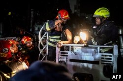 Firefighters extract victims after a fire race through a commercial building in Dhaka, Bangladesh, Feb. 29, 2024.