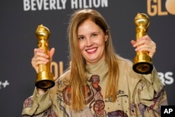 Justine Triet berpose dengan dua penghargaan yang diperolehnya dalam film "Anatomy of a Fall" untuk skenario film terbaik dan film berbahasa asing terbaik di ruang pers Golden Globe Awards ke-81 di Beverly Hilton, Beverly Hills, California, 7 Januari 2024. (AP/Chris Pizzello).