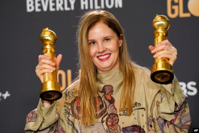 Justine Triet berpose dengan dua penghargaan yang diperolehnya dalam film "Anatomy of a Fall" untuk skenario film terbaik dan film berbahasa asing terbaik di ruang pers Golden Globe Awards ke-81 di Beverly Hilton, Beverly Hills, California, 7 Januari 2024. (AP/Chris Pizzello).
