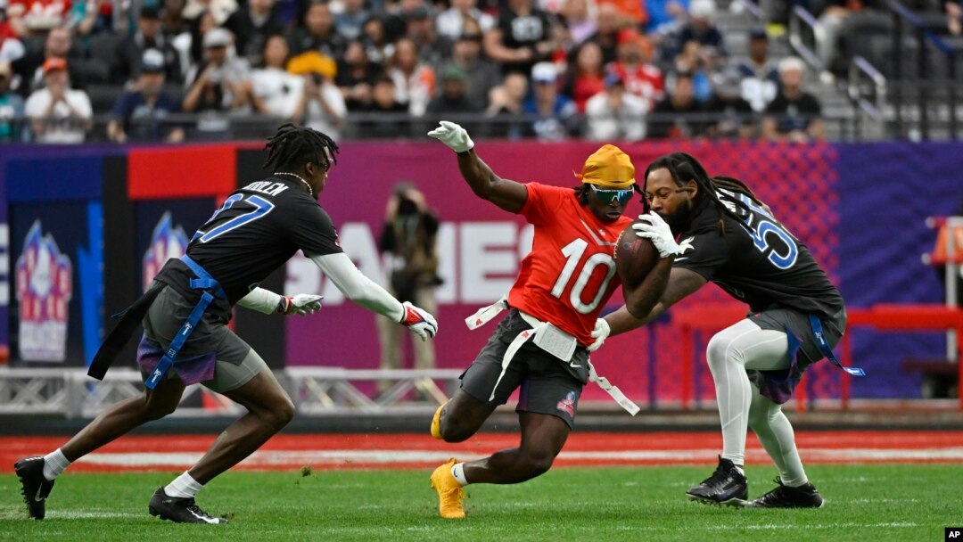 FILE - Tyreek Hill (10) dari Miami Dolphins membawa bola melawan cornerback NFC Tariq Woolen (27) dari Seattle Seahawks dan gelandang luar Za'Darius Smith (55) dari Minnesota Vikings pada pertandingan sepak bola NFL Pro Bowl, di Las Vegas, 5 Februari 2023. (AP/David Becker, File)