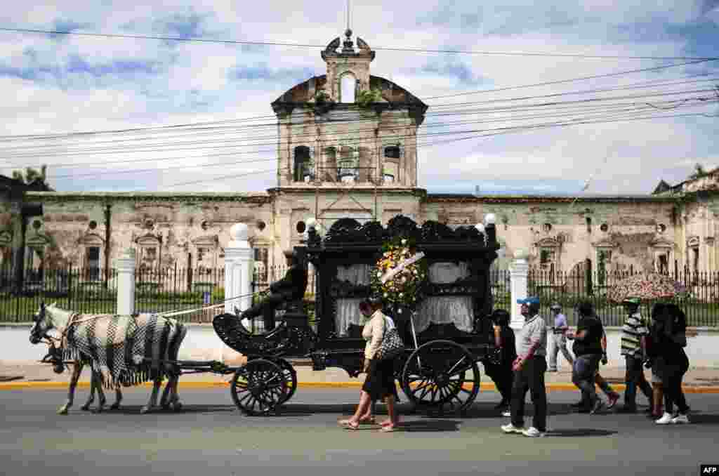 Coachman Ariel Corea drives a horse-drawn hearse during a funeral service in Granada, Nicaragua.