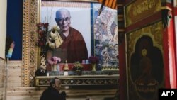 In this photo taken on December 9, 2015, a man prays below a portrait of the Dalai Lama at Kirti Monastery in Aba