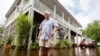 Charles Grainger cleans up around his house in the historic district of French Quarter Creek as flood waters recede from Tropical Storm Debby in Huger, South Carolina, Aug. 7, 2024.