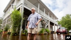 Charles Grainger cleans up around his house in the historic district of French Quarter Creek as flood waters recede from Tropical Storm Debby in Huger, South Carolina, Aug. 7, 2024.