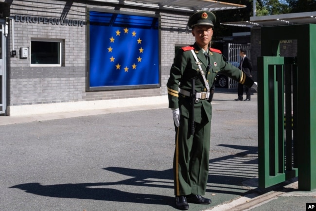 FILE - A Chinese paramilitary policeman stands guard at the entrance to the European Union Delegation to China compound in Beijing, Oct. 14, 2023.