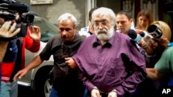 FILE — Romanian guru Gregorian Bivolaru is escorted to a vehicle after a hearing at the Romanian Police headquarters in Bucharest, Romania, Aug. 24, 2016. 