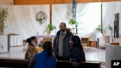 Priest Andrea Conocchia, third from left, speaks with transgender women, from left, Andrea Paola Torres Lopez, Claudia Vittoria Salas and Carla Segovia as they sit in the Beata Vergine Immacolata parish church in Torvaianica, Italy, Nov. 16, 2023.