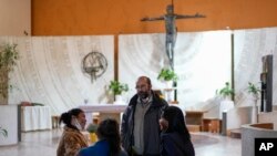 Pastor Andrea Conocchia (ketiga dari kiri) berbincang dengan para transpuan ketika mereka berada di Gereja Paroki Beata Vergine Immacolata di Torvaianica, Italia, pada 16 November 2023. (Foto: AP/Andrew Medichini)