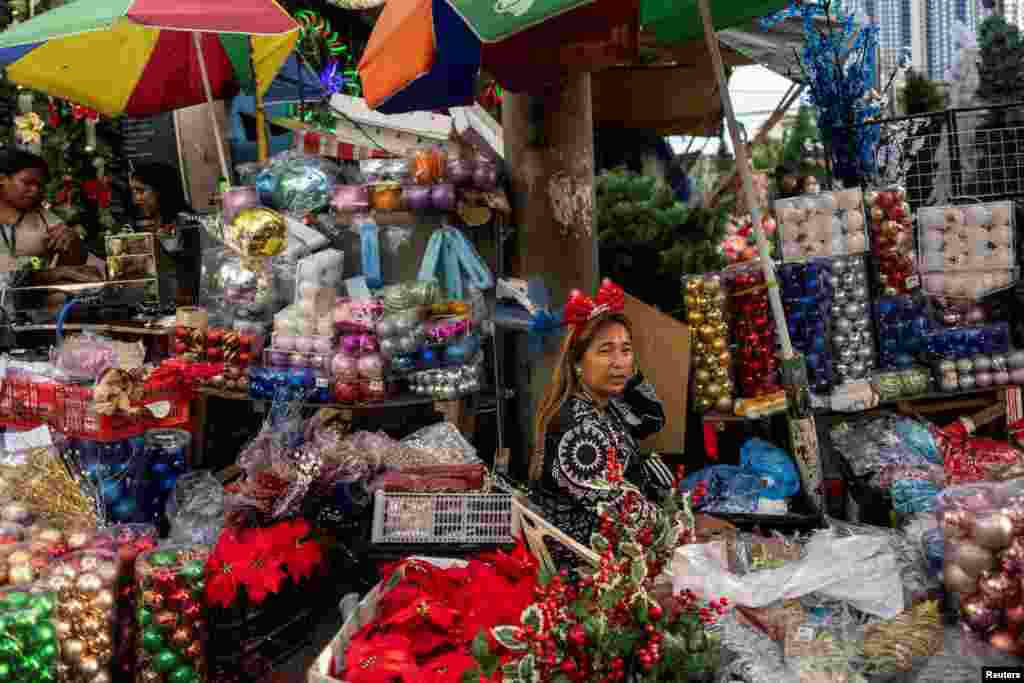 A vendor selling Christmas decorations waits for customers at a street market in Quezon City, Metro Manila, Philippines.