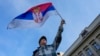 Ilustracija - Učesnik protesta "Srbija protiv nasilja" maše zastavom Srbije (AP Photo/Darko Vojinovic)