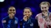 Fencing gold medalist Lee Kiefer, center, of the US celebrates with silver medalist Lauren Scruggs, left, of the US and bronze medalist Eleanor Harvey of Canada during the 2024 Summer Olympics, July 28, 2024, in Paris.