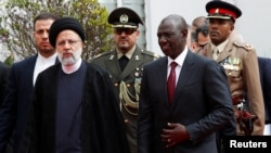 Iran's President Ebrahim Raisi walks with Kenya's President William Ruto after addressing a joint news conference at the State House in Nairobi, Kenya, July 12, 2023.