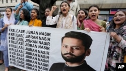 Members of a civil society group hold a banner with the picture of Pakistani human rights lawyer Jibran Nasir during a demonstration to condemn his abduction, in Karachi, Pakistan, June 2, 2023.