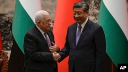 中国国家主席习近平和巴勒斯坦国总统阿巴斯2023年6月14日在中国北京人民大会谈举行的签字仪式后握手祝贺。