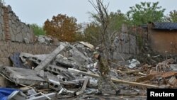 FILE - A police officer searches for parts of a missile at a site of a building damaged by a Russian strike, in Zaporizhzhia, Sept. 3, 2024. The Russian Defense Ministry said Monday that its forces had “liberated” the village of Levadne and occupied better positions in the area.