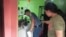 A policeman, left, inspects the area where a radio anchor was fatally shot by a man inside his home-based station in Calamba town in Misamis Occidenta province, southern Philippines, Nov. 5, 2023. 
