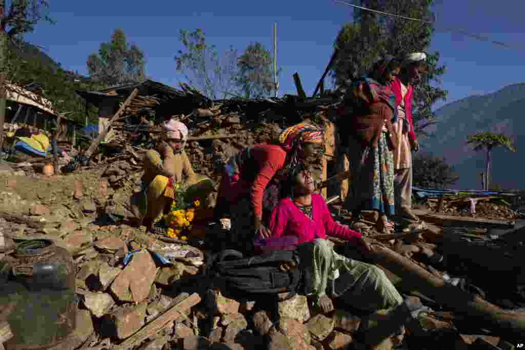 A woman cries near the earthquake damaged house where her son, daughter in law and grand child died in Jajarkot district, northwestern Nepal.
