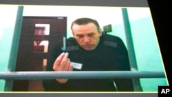 Russian opposition leader Alexey Navalny is seen on a TV screen as he appears in a video link provided by the Russian Federal Penitentiary Service from the colony in Melekhovo, Vladimir region, during a hearing at the Russian Supreme Court in Moscow, Russia, June 22, 2023. 