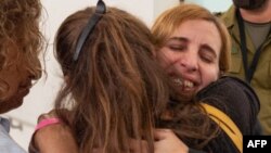 This picture released by Israel's army, courtesy of the hostages' families, on Nov. 25, 2023, shows former Hamas captive Danielle Aloni embracing a relative at a hospital in Israel. Aloni and her daughter became friends with Nutthawaree Munkan, of Thailand, while being held.
