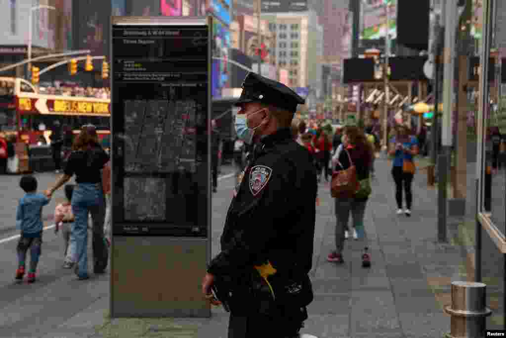 Un miembro de la Policía de Nueva York patrulla Times Square usando una mascarilla para evitar afectaciones por las partículas que hay en el aire.&nbsp;