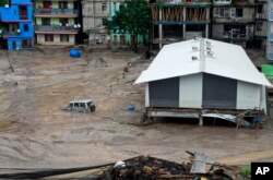 Sebuah kendaraan terlihat sebagian terendam air setelah banjir bandang yang dipicu oleh hujan deras yang tiba-tiba membanjiri Kota Rangpo di Sikkim, India, Kamis, 5 Oktober. 2023. (Foto: AP/Prakash Adhikari)