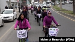 Kadınlar bisikletlerine şiddet karşıtı sloganların yazılı olduğu bezler astı.