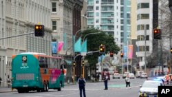 Armed police stand in the street following a shooting in the central business district of Auckland, New Zealand, July 20, 2023. A gunman killed two people before he died Thursday at a construction site.