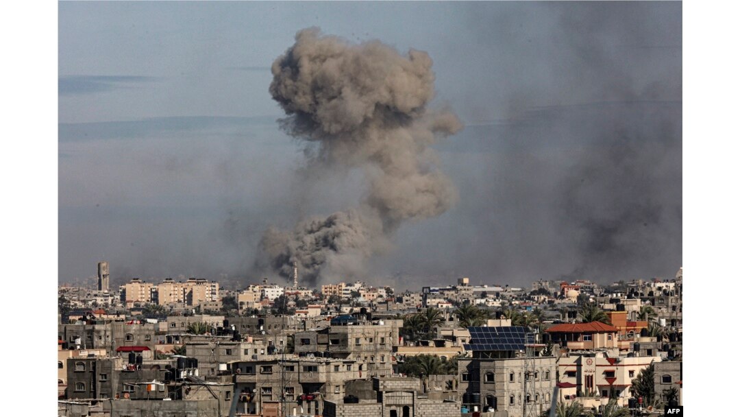 Gambar yang diambil dari Rafah menunjukkan asap mengepul di Khan Yunis di Jalur Gaza selatan selama pengeboman Israel pada 13 Januari 2024. (Foto: AFP)