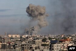 Gambar yang diambil dari Rafah menunjukkan asap mengepul di Khan Yunis di Jalur Gaza selatan selama pengeboman Israel pada 13 Januari 2024. (Foto: AFP)