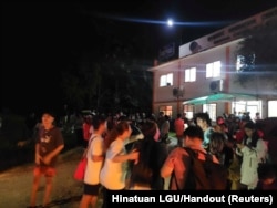 People gather in the aftermath of an earthquake in Hinatuan, Surigao del Sur, Philippines, Dec. 2, 2023.