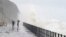 People stand on the promenade in Folkestone, England, Nov. 2, 2023, as Storm Ciaran brings high winds and heavy rain to the southern coast of England.