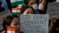 Members of the Kuki tribe, protesting the killing of tribals in their northeastern home state of Manipur, hold Indian flags and placards during a sit-in in New Delhi, India,  May 29, 2023.
