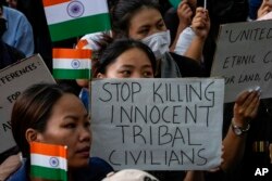 Members of the Kuki tribe, protesting the killing of tribals in their northeastern home state of Manipur, hold Indian flags and placards during a sit-in in New Delhi, India, May 29, 2023.