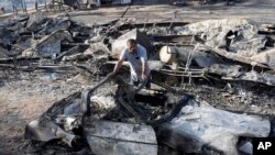 Luis Quinonez surveys the damage to his property after the Highland Fire passed through, Oct. 31, 2023, in Aguanga, California.