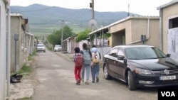 Children return from school in the Tserovani settlement.  (Lisa Bryant/VOA)