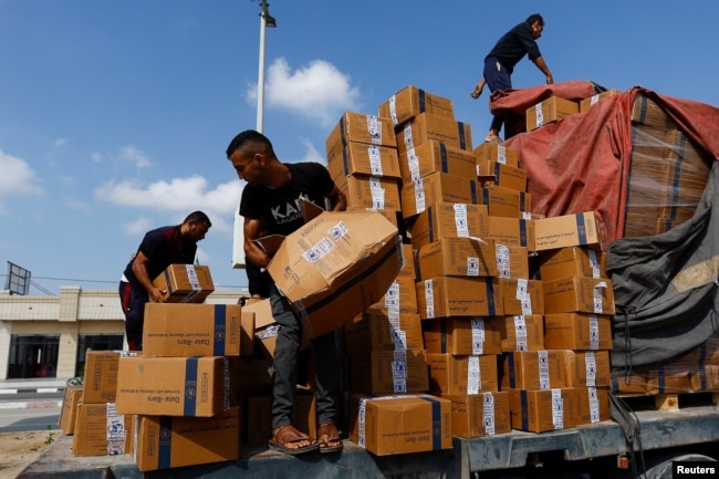 Palestinians reload a truck with aid that fell from the vehicle, amid shortages of food supplies, during the ongoing conflict between Israel and Palestinian Islamist group Hamas, in Rafah in the southern Gaza Strip, Nov. 2, 2023.