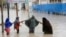 ILUSTRASI - Perempuan berjalan melewati air banjir setelah hujan lebat, di Mogadishu Somalia, Senin, 20 November 2023. (AP/Farah Abdi Warsame)