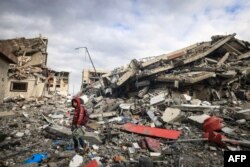 Palestinians inspect the destruction caused by Israeli strikes in Wadi Gaza, in the central Gaza Strip on Nov. 28, 2023, amid a truce in battles between Israel and Hamas.