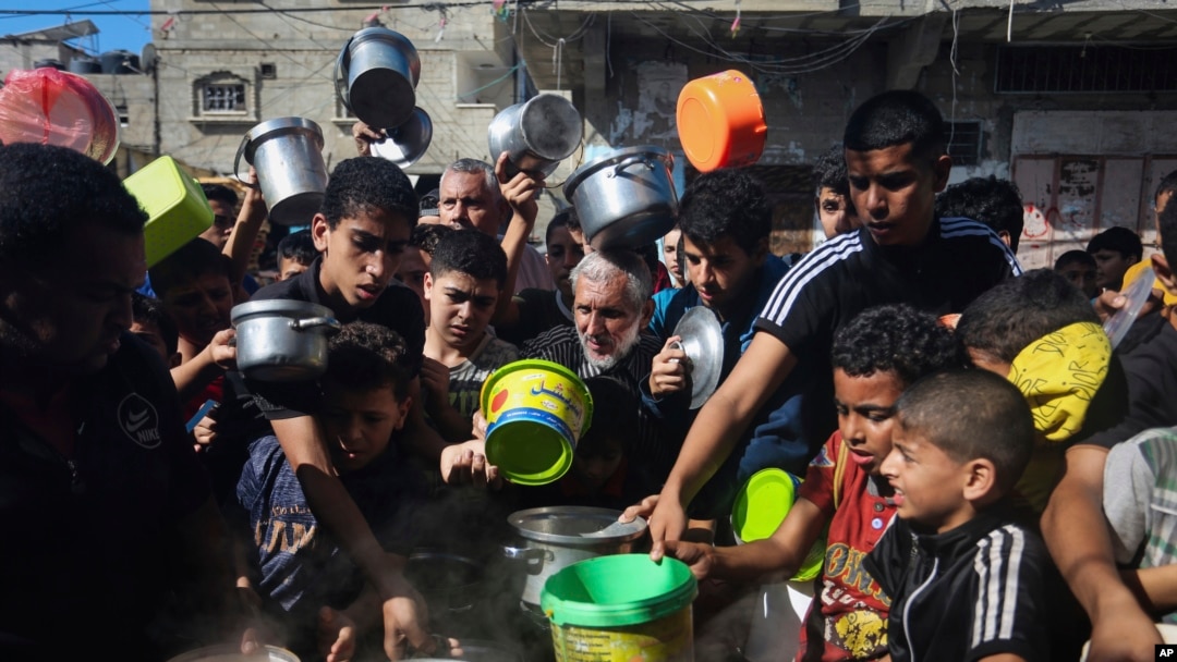 FILE - Palestinians crowd together as they wait for food distribution in Rafah, southern Gaza Strip, Nov. 8, 2023. 