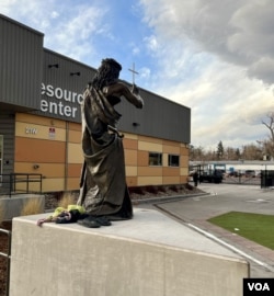 An over-sized bronze sculpture is of Jesus wearing a crown of thorns with His index finger pointing to a cross atop the Springs Rescue Mission resource center, Jan. 17, 2023. (Carolyn Presutti)