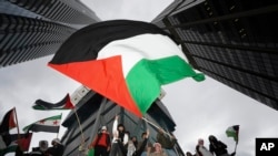 Para pendukung mengibarkan bendera Palestina dalam sebuah mars di Toronto, pada 9 Oktober 2023. (Foto: via AP)