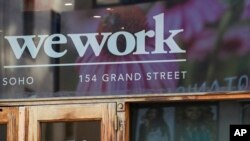 Logo WeWork di pintu masuk salah satu ruang kantor mereka di kawasan SoHo, New York, Selasa, 15 Oktober 2019. (AP/Mary Altaffer)