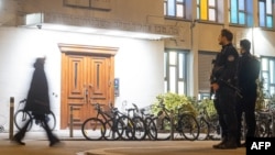 Police officers stand guard at the Agudas Achim Synagogue in Zurich, Switzerland, March 3, 2024, after an Orthodox Jewish man was stabbed in the city's center late on March 2, 2024.